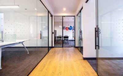 Couloir moderne avec parquet, cloisons vitrées et salle de réunion
