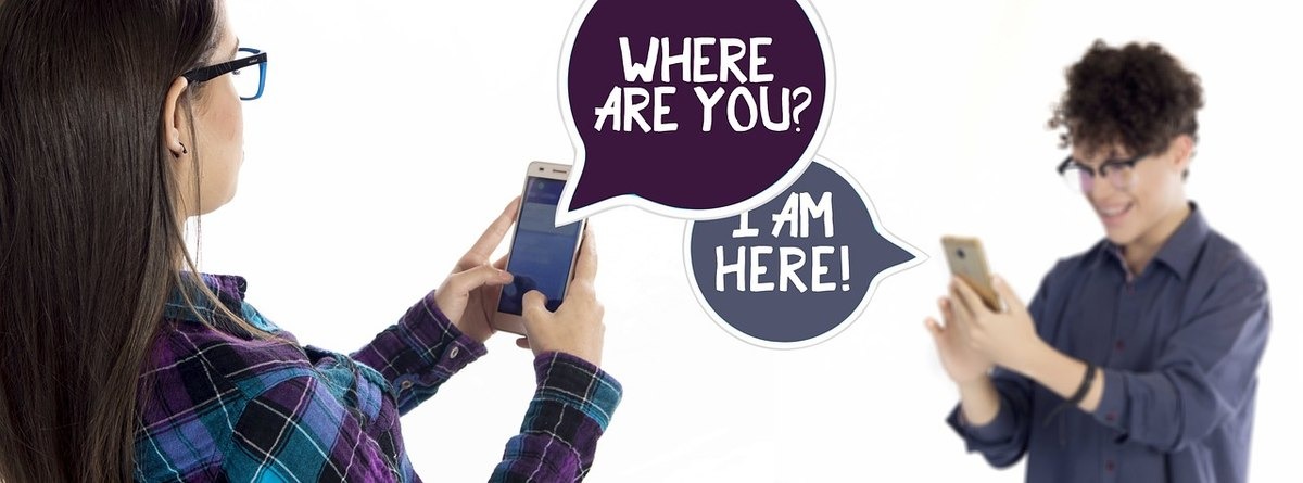 Deux jeunes utilisent leurs smartphones pour communiquer leur position